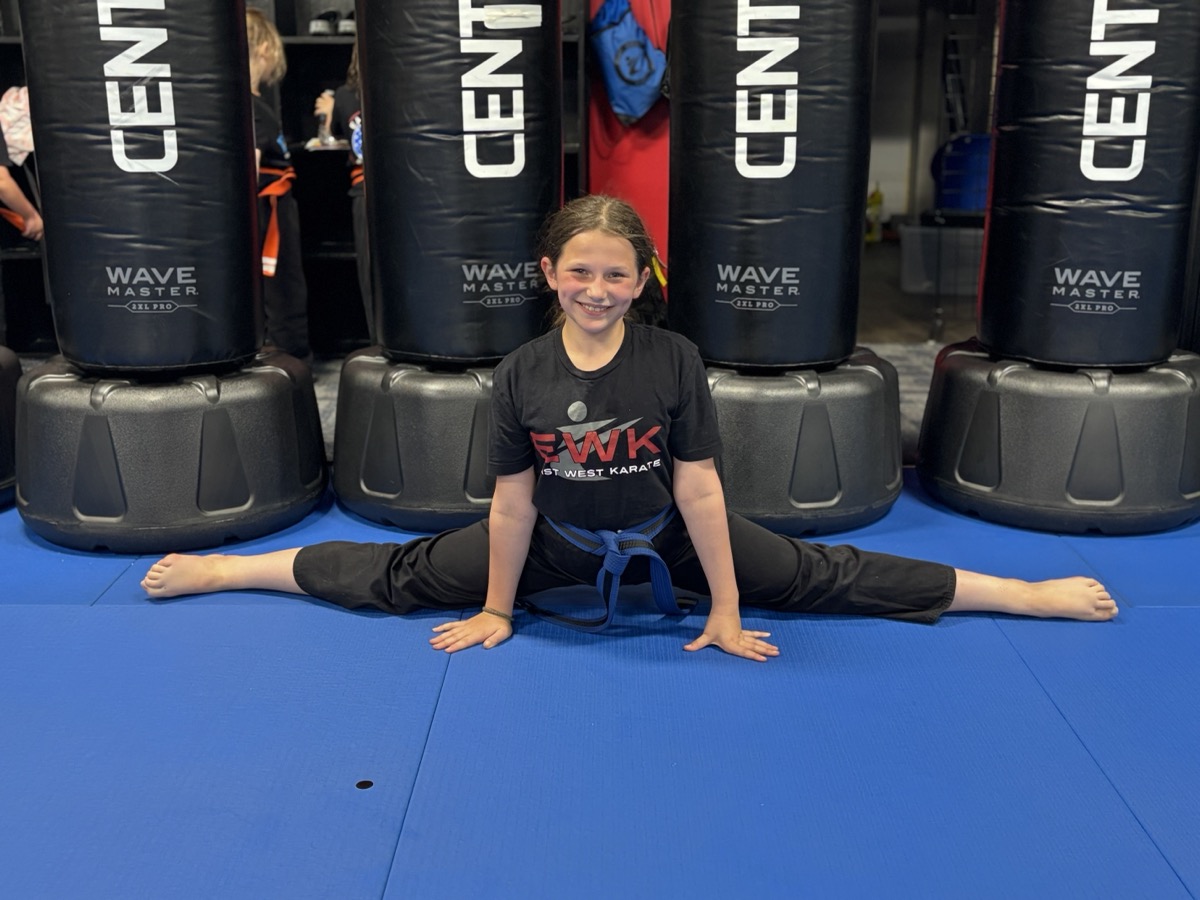 Student demonstrating flexibility with splits at East West Karate