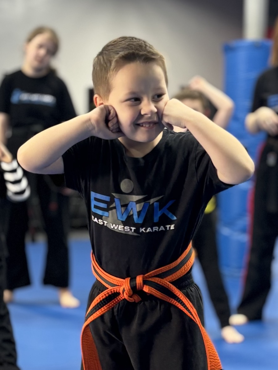 Young martial artist in EWK shirt with fists up at the Trevose dojo