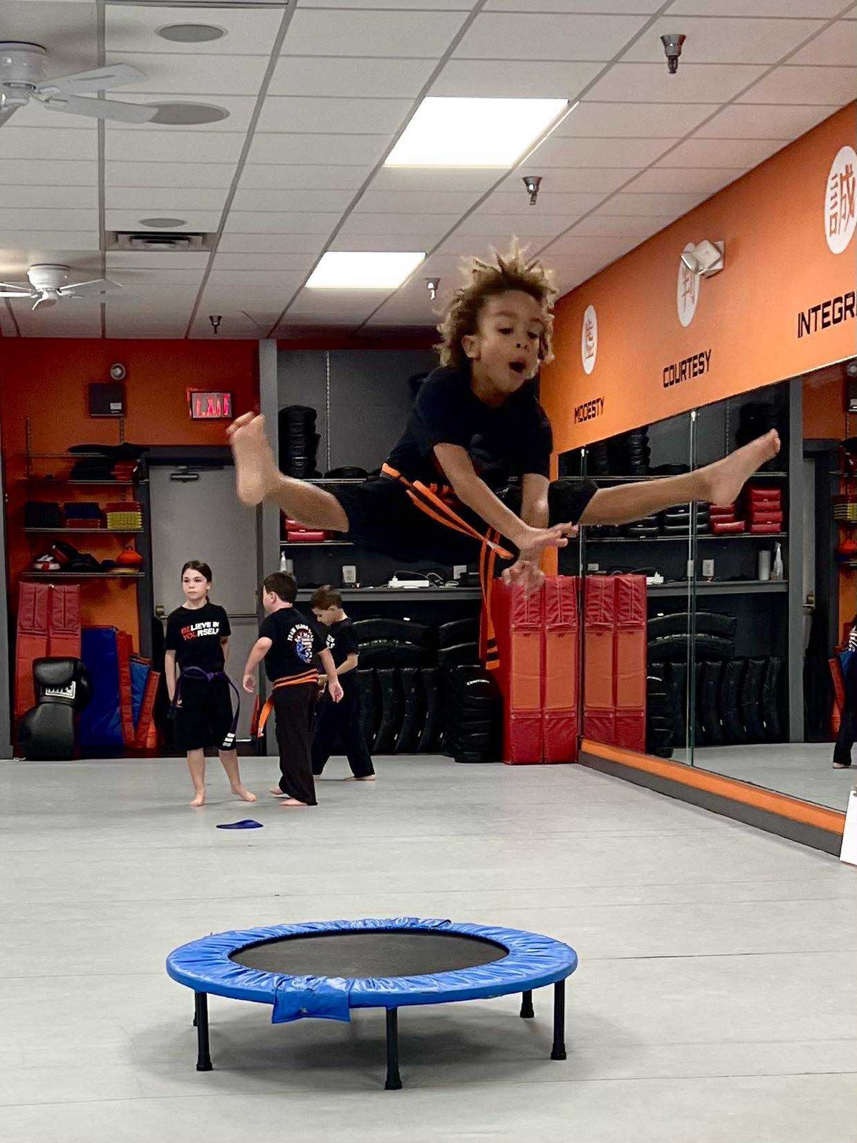 East West Karate student performing a flying kick
